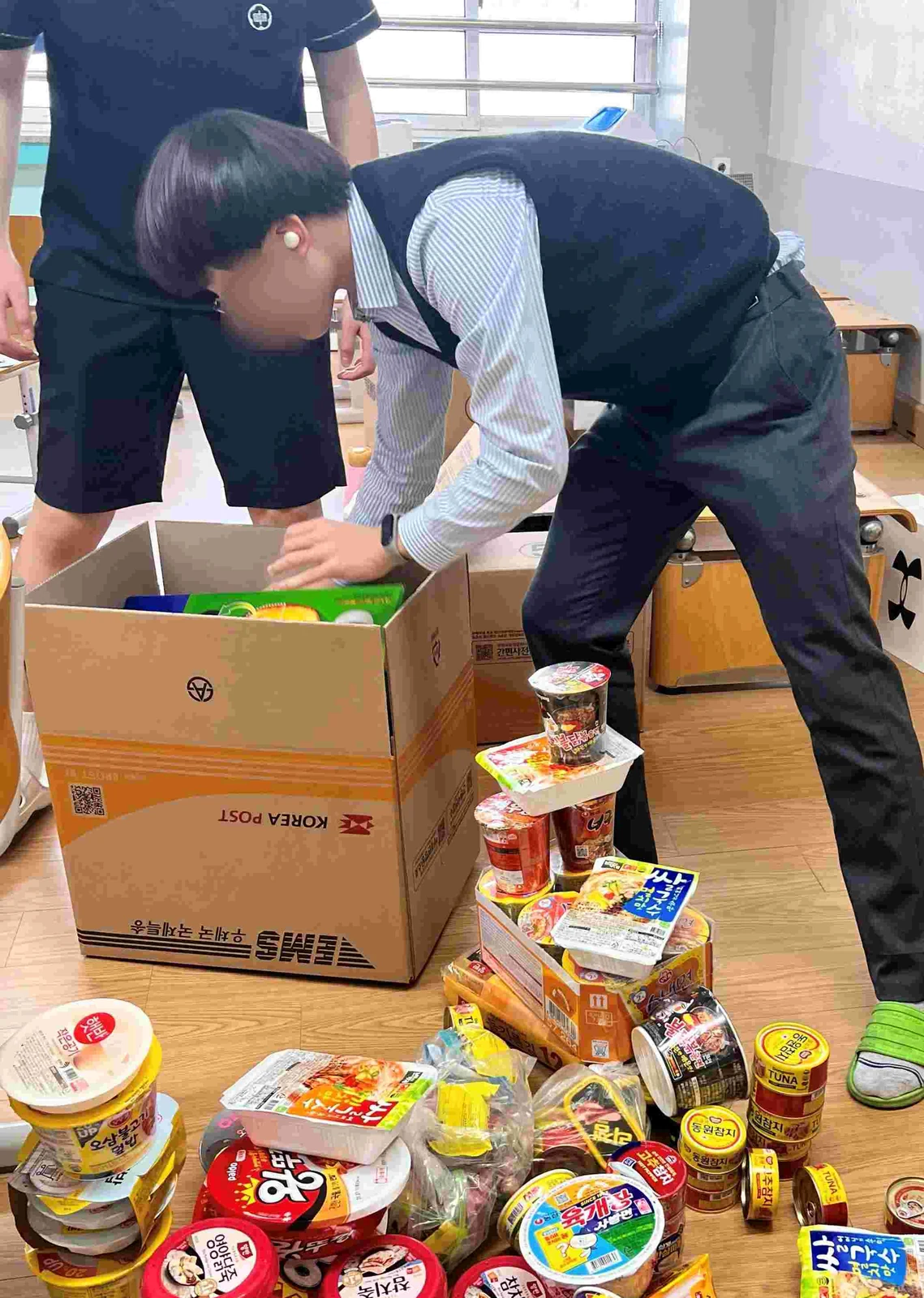학생이 산불 이재민에게 보낼 기부 식품을 분류하고 상자에 포장하는 모습