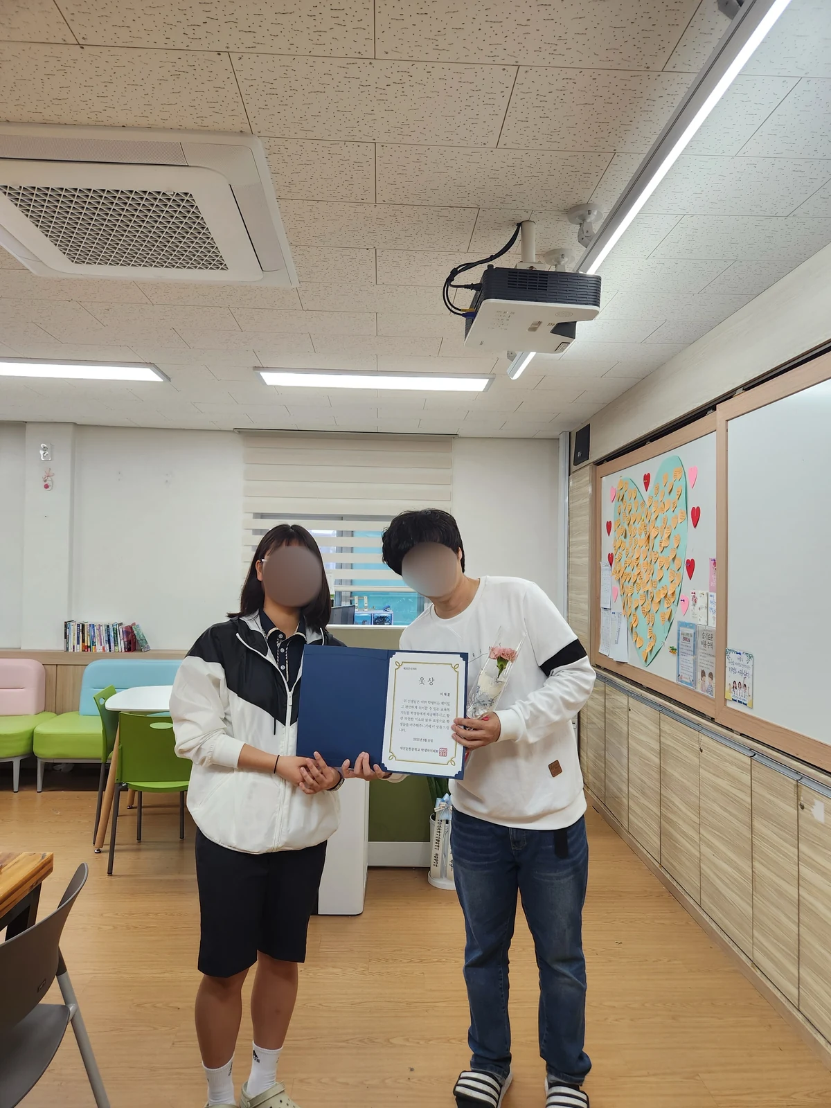 학생과 선생님이 감사장을 함께 들고 기념 촬영한 모습